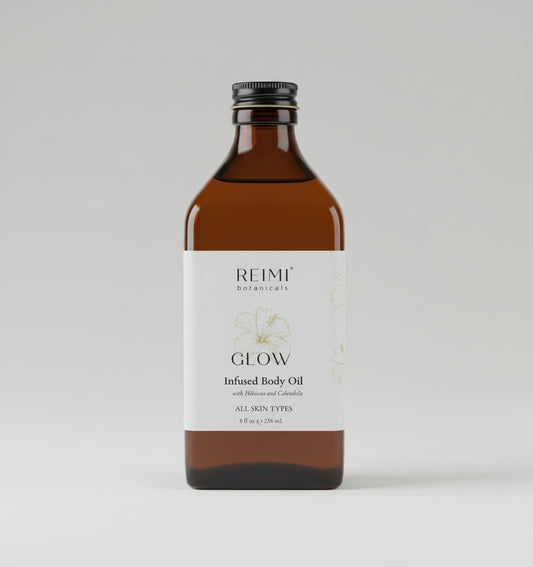 Brown bottle of Reimi Botanicals Glow Infused Body Oil on a textured surface