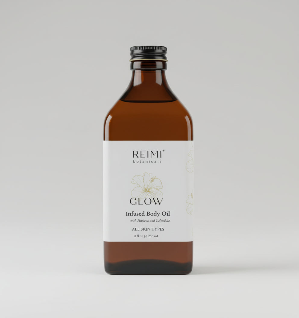 Brown bottle of Reimi Botanicals Glow Infused Body Oil on a textured surface