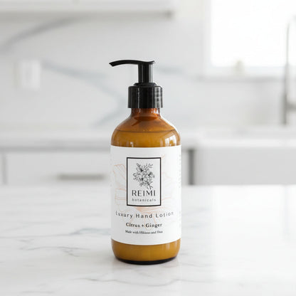 Brown bottle of Reimi Botanicals hand lotion on a wooden surface with a striped fabric background.