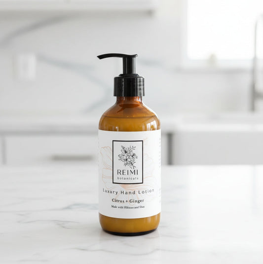 Brown bottle of Reimi Botanicals hand lotion on a wooden surface with a striped fabric background.