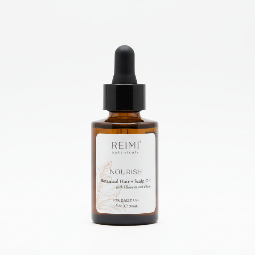 Amber glass bottle of Nourish Botanical Hair + Scalp Oil with white label