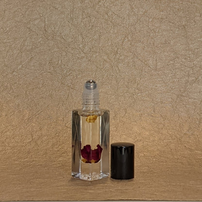 Glass perfume bottle in front of a gold textured background.